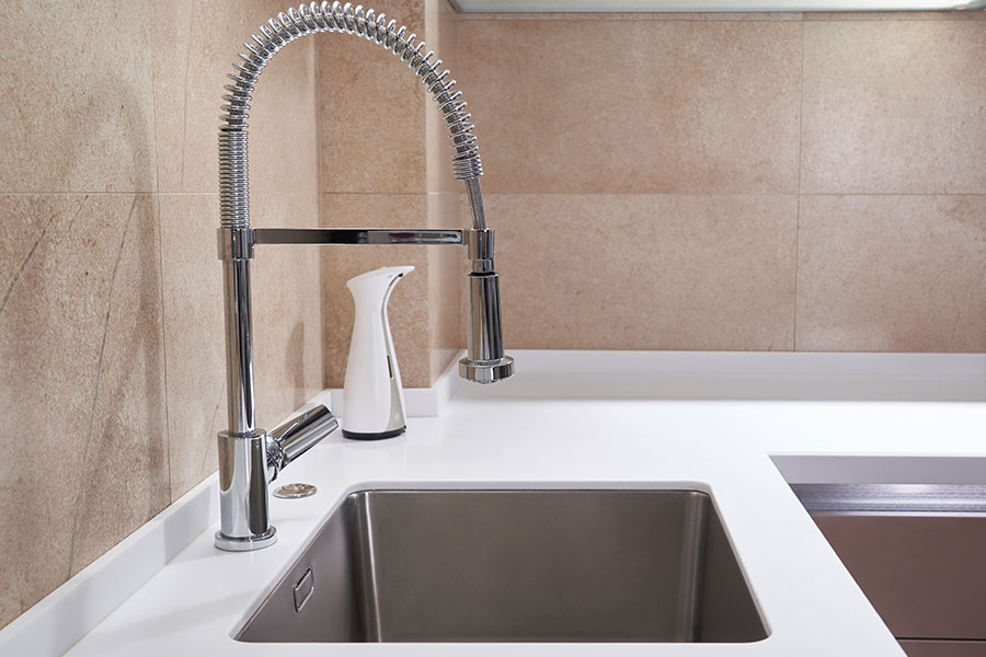 Modern kitchen sink with a high-arc spring faucet and stainless steel basin