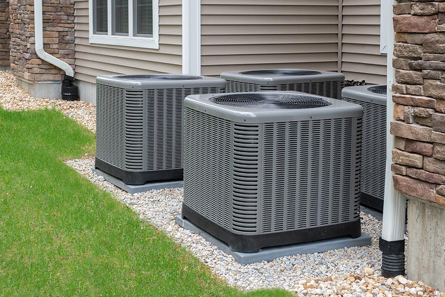 Multiple outdoor air conditioning units installed next to a house